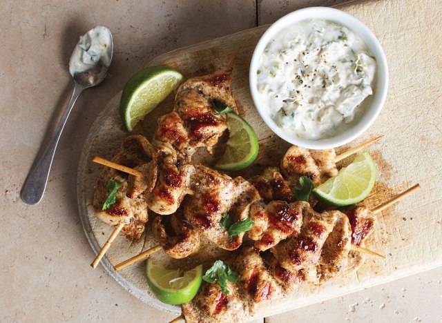 brochetas de pollo garam masala con salsa en tabla de madera