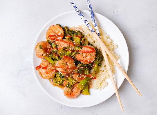 camarones y brócoli con sriracha en un plato con arroz de coliflor